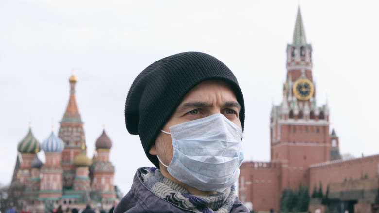 Un barbat din Piata Rosie, Moscova, poarta masca de protectie anti-COVID