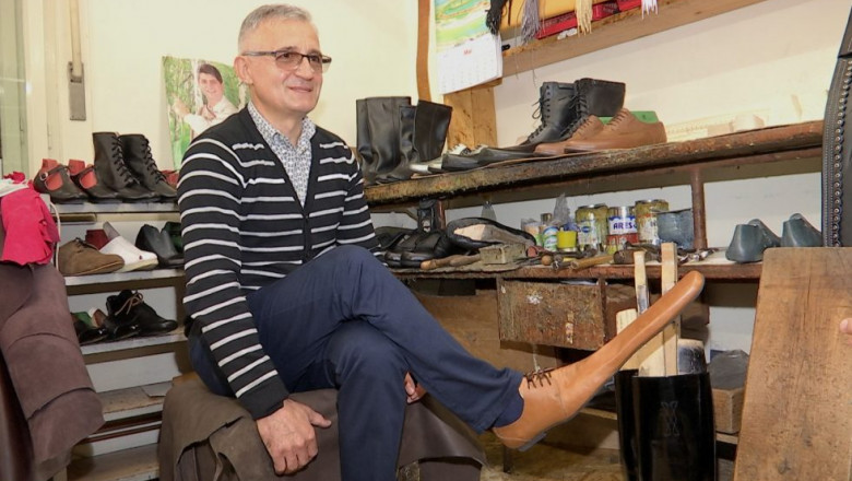 Grigore Lup poartă o pereche de pantofi de distanțare socială pe care i-a creat chiar el
