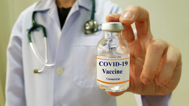 un medic prezinta o mostra dintr-un vaccin anti-covid