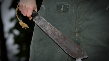 Crazed man wearing wielding a machete