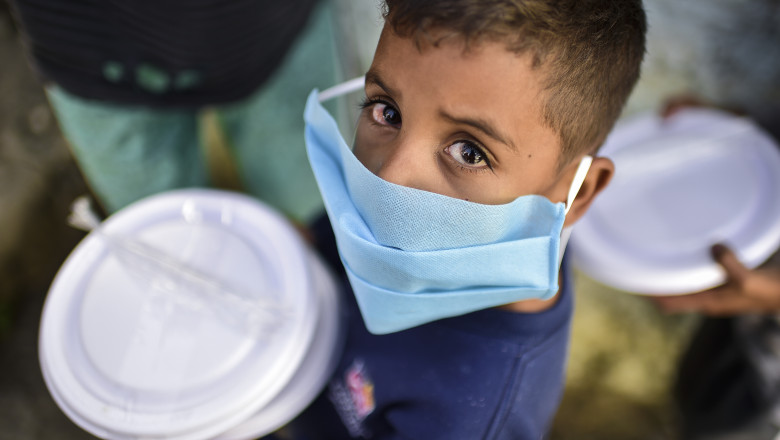 Copil cu mască sanitară în favele, în Brazilia
