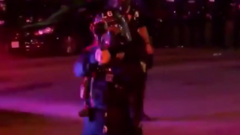 politist trage cu un lansator de gaze lacrimogene spre o echipa de jurnalisti