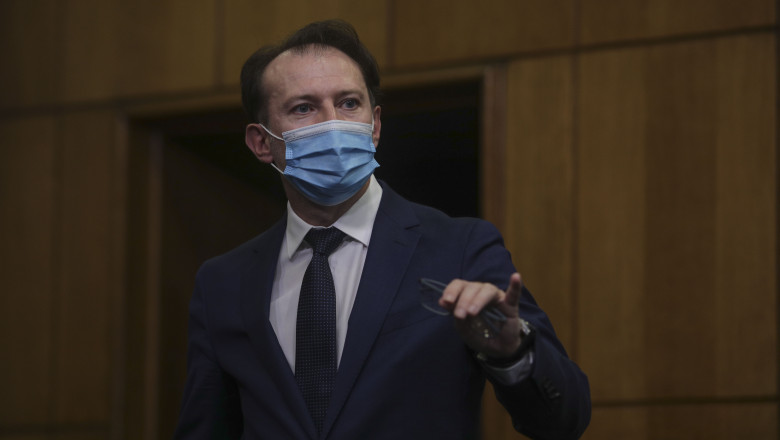 ministrul Finanțelor, Florin Cîțu gesticulează, cu masca pe față, la Guvern