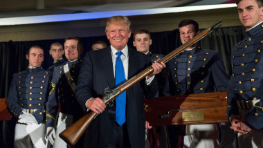 Donald Trump ține o pușcă în mână