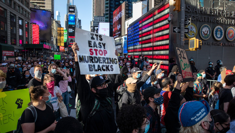 NEW YORK, NEW YORK - MAY 31: Black Lives Matter protesters kneel in Times Square during a march to honor George Floyd in Midtown Manhattan on May 31, 2020 in New York City. Protesters demonstrated for the fourth straight night after video emerged of a Minneapolis police officer, Derek Chauvin, pinning George Floyd's neck to the ground. Floyd was later pronounced dead while in police custody after being transported to Hennepin County Medical Center. The four officers involved have been fired and Chauvin has been arrested and charged with 3rd degree murder. (Photo by John Moore/Getty Images)