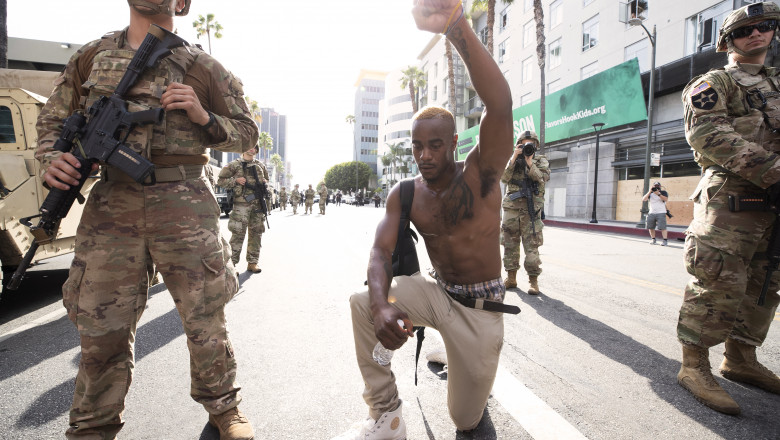 LOS ANGELES, CALIFORNIA - JUNE 2: A demonstrator kneels during a march in response to George Floyd's death on June 2, 2020 in Los Angeles, California. Floyd died while in Minneapolis police custody on May 25. Officer Derek Chauvin and three other policemen involved in the incident have been fired from the force. Chauvin has since been arrested and charged with third degree murder. Huge peaceful protests, many marred by vandalism and police violence, are taking place throughout the United States. (Photo by Brent Stirton/Getty Images)