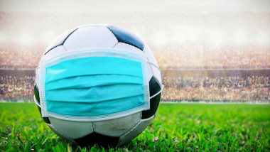 soccer ball with medical mask in the stadium. All event of soccer pause break. covid-19 spreading outbreak