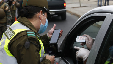SANTIAGO, CHILE - MARCH 27: A police officer wearing a face mask controls access of a driver to the quarantine area during the first day of the lock down in seven communes of the capital on March 27, 2020 in Santiago, Chile. Around 1.3 million people of seven communes of Santiago de Chile must be under total quarantine for seven days starting yesterday at 10PM to halt spread of COVID-19. (Photo by Marcelo Hernandez/Getty Images)