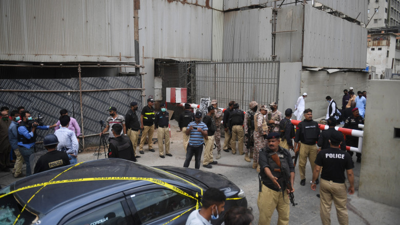 Personalul de securitate păzește intrarea principală a clădirii Bursei din Pakistan, în Karachi, după un atac armat.