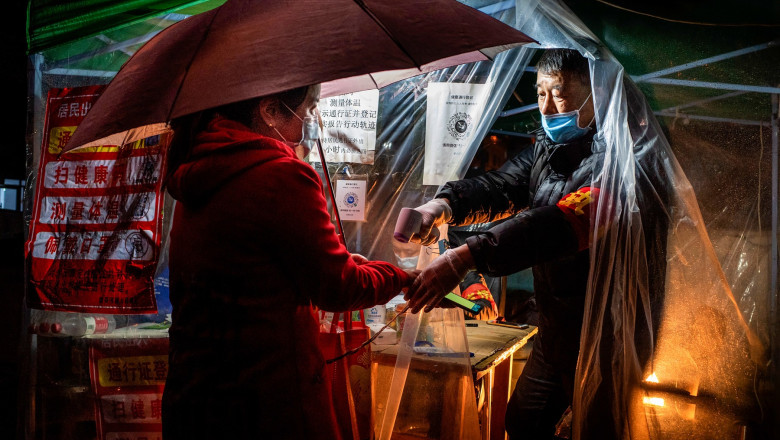 un barbat chinez ia temperatura unei femei cu umbrela