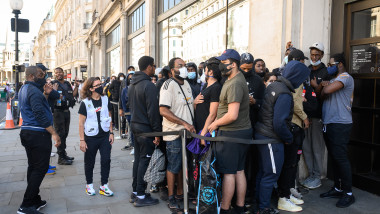 oamenii stau la coada in fata unui magazin din Londra dupa redeschidere pandemie