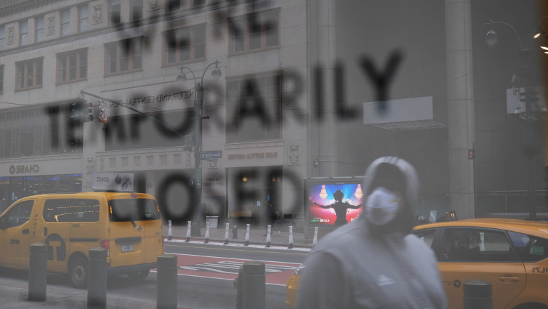Pandemia de coronavirus în New York, un trecător trece pe lângă un magazin închis temporar