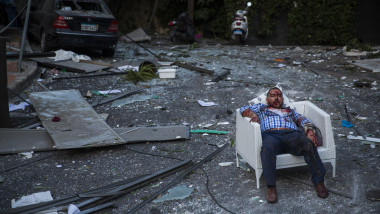 Un bărbat rănit în urma exploziei din Beirut este așezat pe un fotoliu.