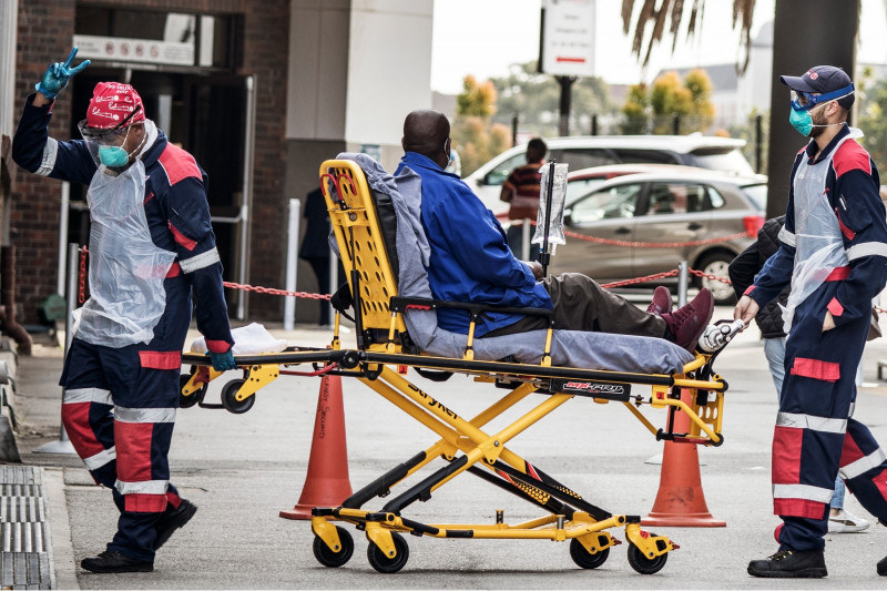 paramedici cară pe targă un pacient cu COVID în Africa de Sud