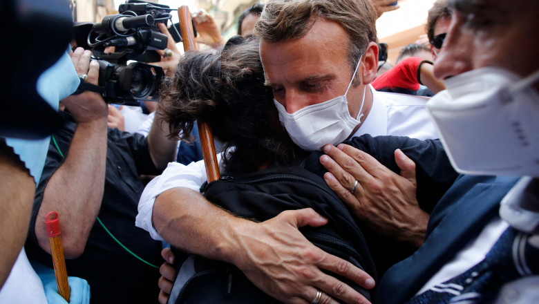 Președintele francez Emmanuel Macron îmbrățișează o locuitoare din Beirut în timpul vizitei din 6 august făcute după explozia devastatoare din portul capitalei libaneze