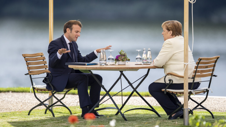 Emmanuel Macron stă de vorbă cu Angela Merkel la o terasă