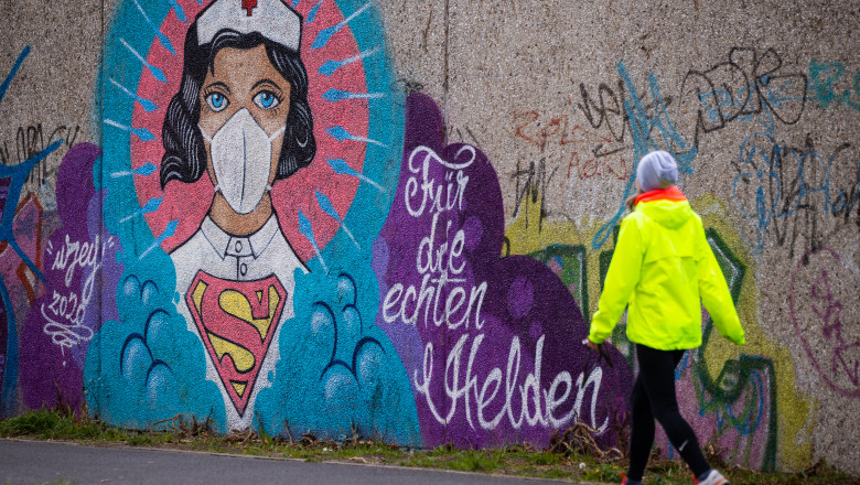 HAMM, GERMANY - APRIL 14: A women walks past street art painted by artist Kai 'Uzey' Wohlgemuth featuring a nurse as Superwoman on April 14, 2020 in Hamm, Germany. So far, over there are over 130,000 confirmed cases of coronavirus infection in Germany, over 3,000 people have died and over 57,000 people have recovered. (Photo by Lars Baron/Getty Images)