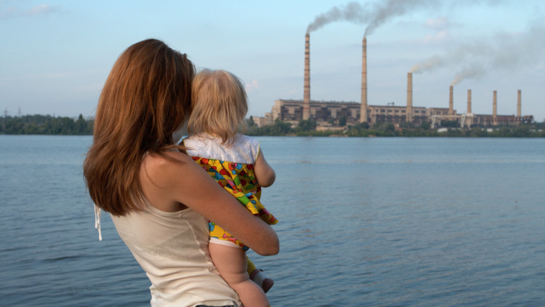 Mamă cu copil poluare fabrică