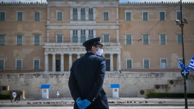 Polițist cu mască și mânuși anti-Covid-19 în fața parlamentului grec.
