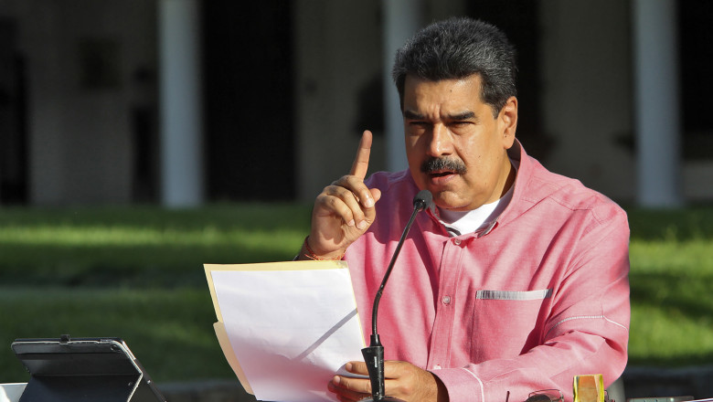 preşedintele Venezuelei, Nicolas Maduro, citeşte de pe o foaie, cu un deget ridicat în aer