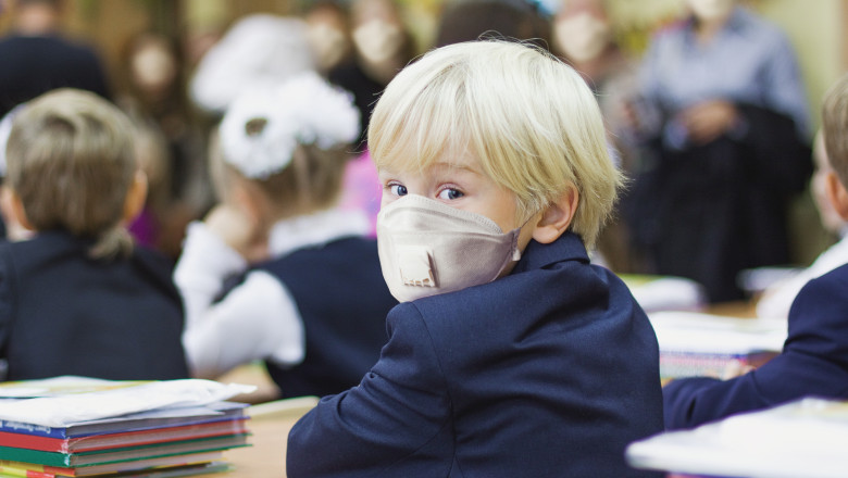 Elev mic purtand masca de protectie in clasa