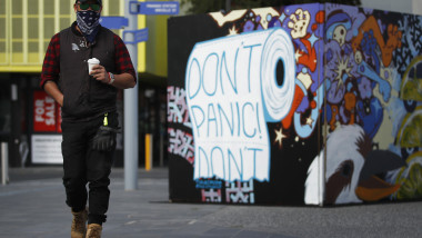 Un bărbat din Melbourne trece pe lângă un grafitti cu mesajul „Nu te panica!” Foto: GettyImages