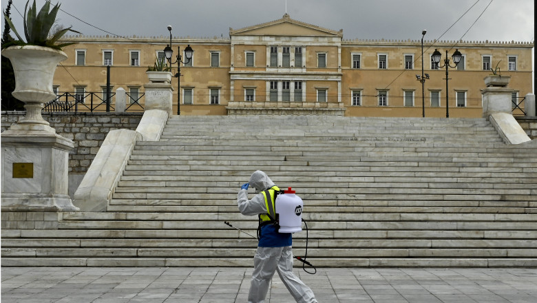 Un funcționar dezinfectează piața Syntagma din Atena.