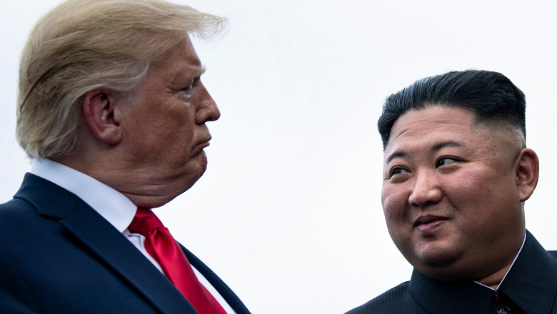 Donald Trump și Kim Jong-un se privesc în ochi în timpul întâlnirii celor doi lideri la Zona Demilitarizată dintre cele două Corei.