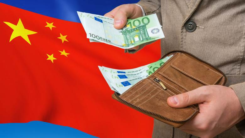 barbat scotand din portofel bancnote de euro pe fondul unui steag al chinei