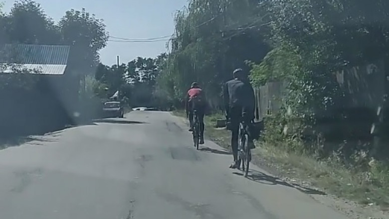 doi biciclisti merg pe sosea unul in fata celuilalt
