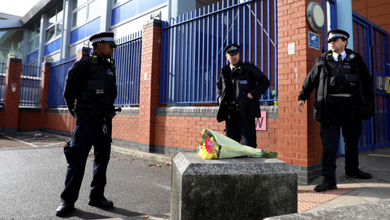 trei polițiști si un buchet de flor in fata unei sectii de politiei