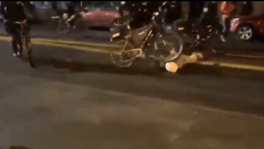 . Un polițist trece cu bicicleta peste capul unui protestatar