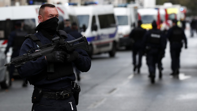 Un politist inarmat sta langa fostul sediul al revistei Charlie Hebdo, dupa atacul cu maceta de vineri