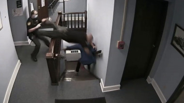 Un polițist se aruncă pe scări, cu capul înainte, încercând să prindă un infractor fugar