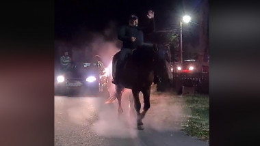 primarul comunei drăguțești călare pe un cal în timpul nopții, urmat de un convoi de mașini