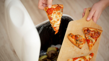 un om aruncă pizza la cosul de gunoi
