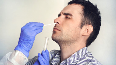 doctor in a protective suit taking a nasal swab from a person to test for possible coronavirus infection. Nasal mucus testing for viral infections.