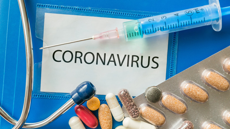 o seringa si medicamente langa o cartie pe care scrie coronavirus,