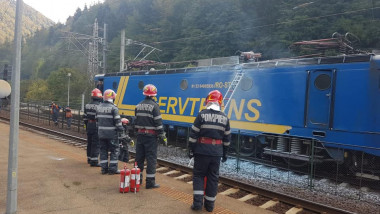 4 pompieri privesc o locomotiva dupa interventia de stingere a incendiului