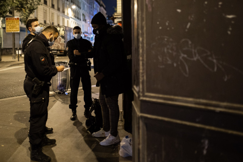 Poliţiştii francezi verifică o persoană pe străzile din Paris, după ora 21