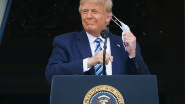 Donald Trump își dă masca jos înainte de a se adresa mulțumii de pe balconul Casei Albe, în prima sa apariție cu public de la externarea din spital