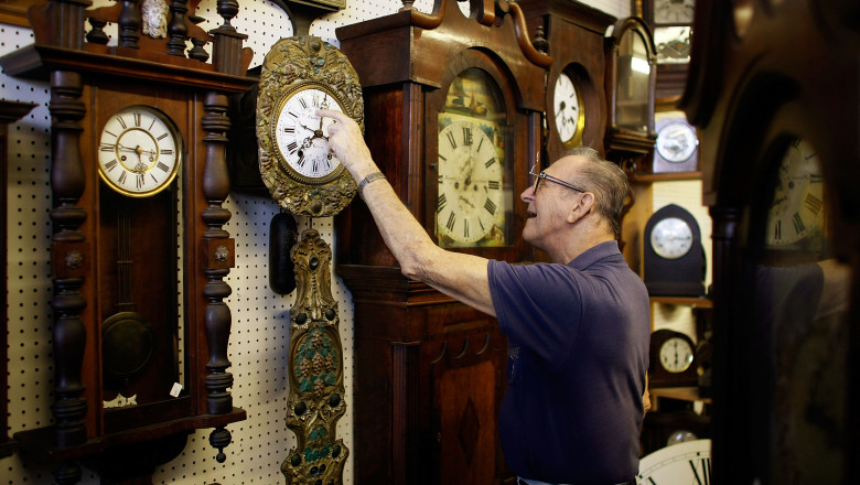 barbat care modifica ceasurile pentru a le ajusta la schimbarea orei