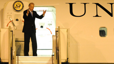 Joe biden pe scara avionului de vicepresedinte al sua, cu mainile ridicate, vesel