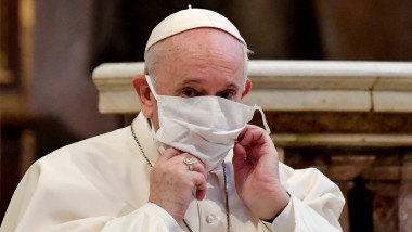 Papa Francisc își aranjează masca în timpul rugăciunii colective pentru pace, unde participă alături de alți lideri religioși, în Biserica Santa Maria din Aracoeli, o biserică veche din Roma