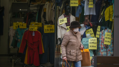 femeie cu masca pe strada in bulgaria, trece prin fata unui magazin