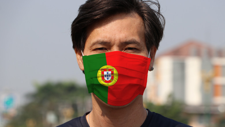 Bărbat care poartă o mască de protecție imprimată cu drapelul Portugaliei