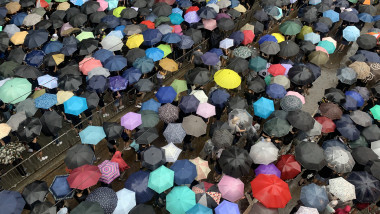 oameni cu umbrele pe strada