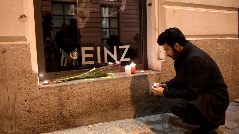 Un tânăr aprinde o candelă în locul în care, luni seară, un vienez a fost ucis de teroriștii islamici