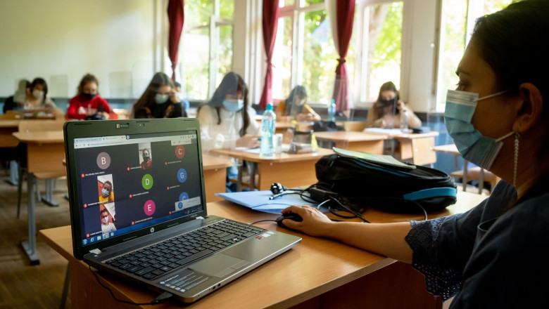 O profesoară din Bucureşti ţine o lecţie online cu laptopul în faţă cu elevii