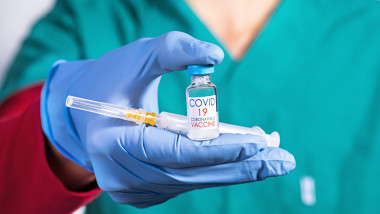 doctor care ține în mână un vaccin covid-19